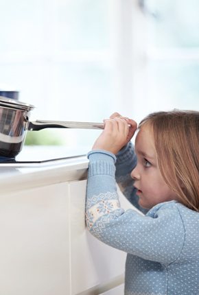 Kind in der Küche beim Spielen mit einem Topf